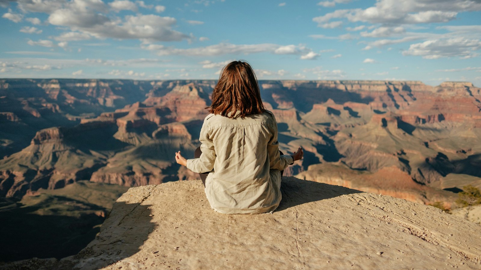 Woman sitting alone on a hillside, looking out